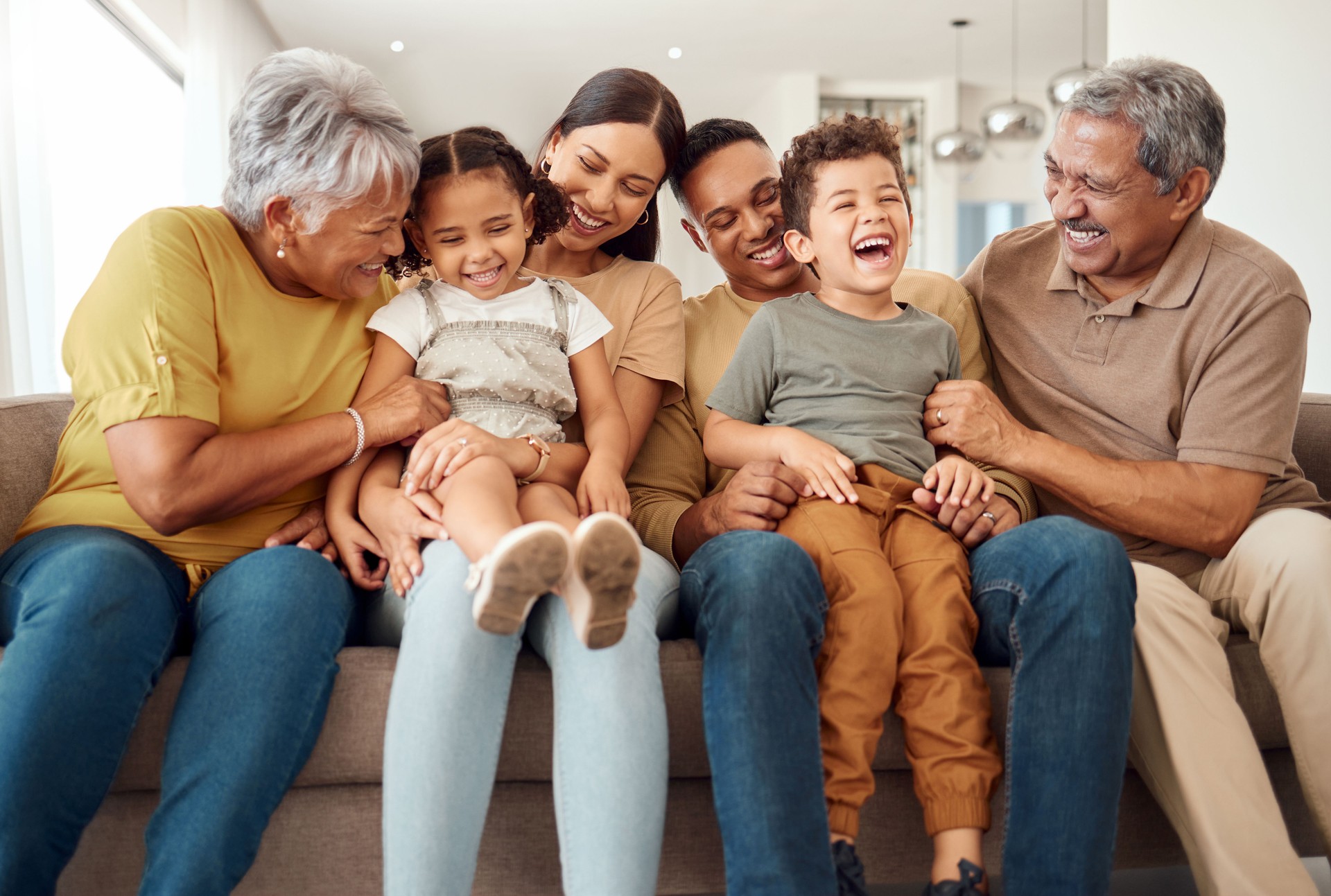 Feliz, gran familia y tiempo de calidad unión de niños, padres y abuelos juntos en un sofá. Niños riendo divirtiéndose con mamá, papá y abuelo en el sofá de la sala de estar de una casa con felicidad